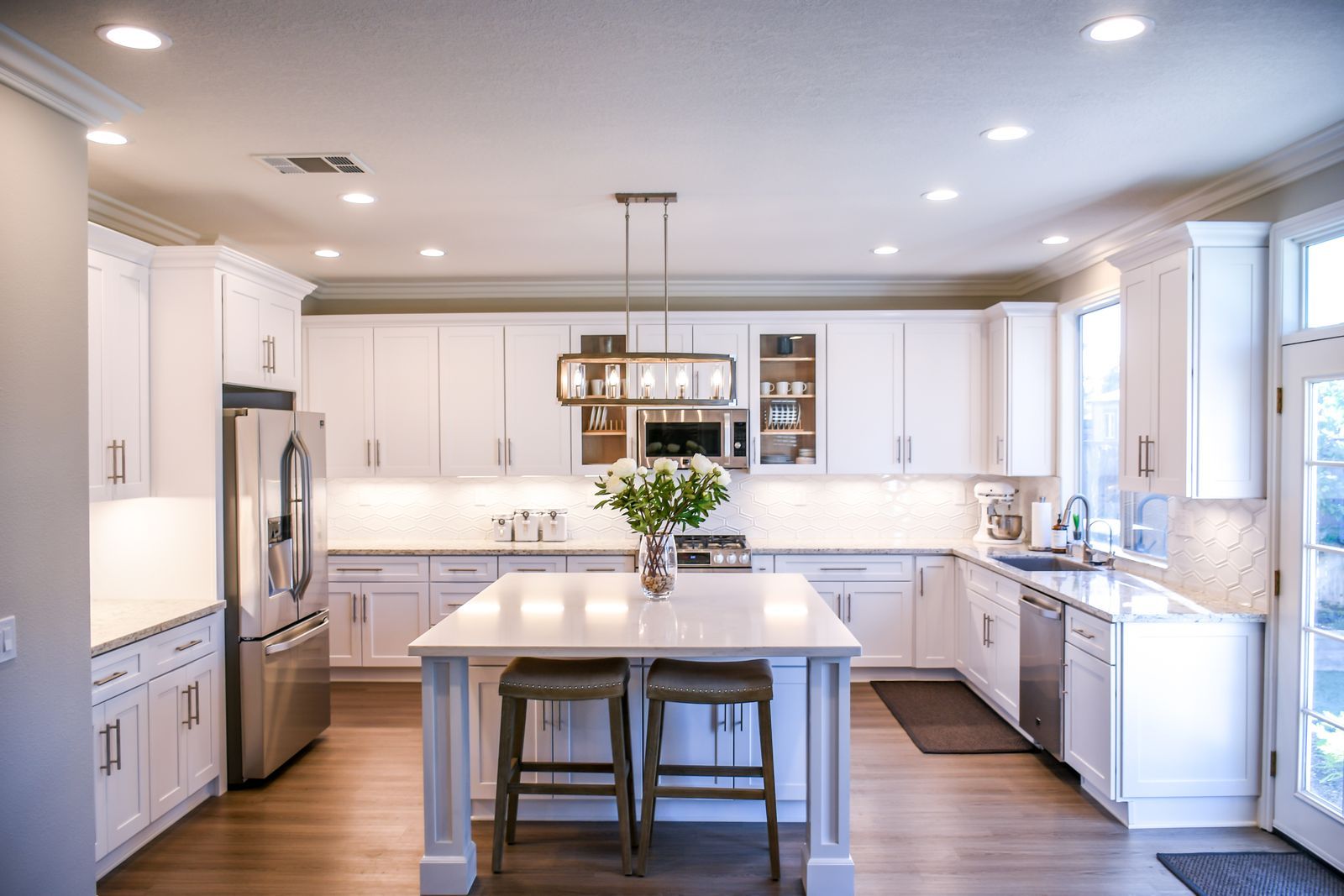 White shaker kitchen with island and glass-front upper cabinets