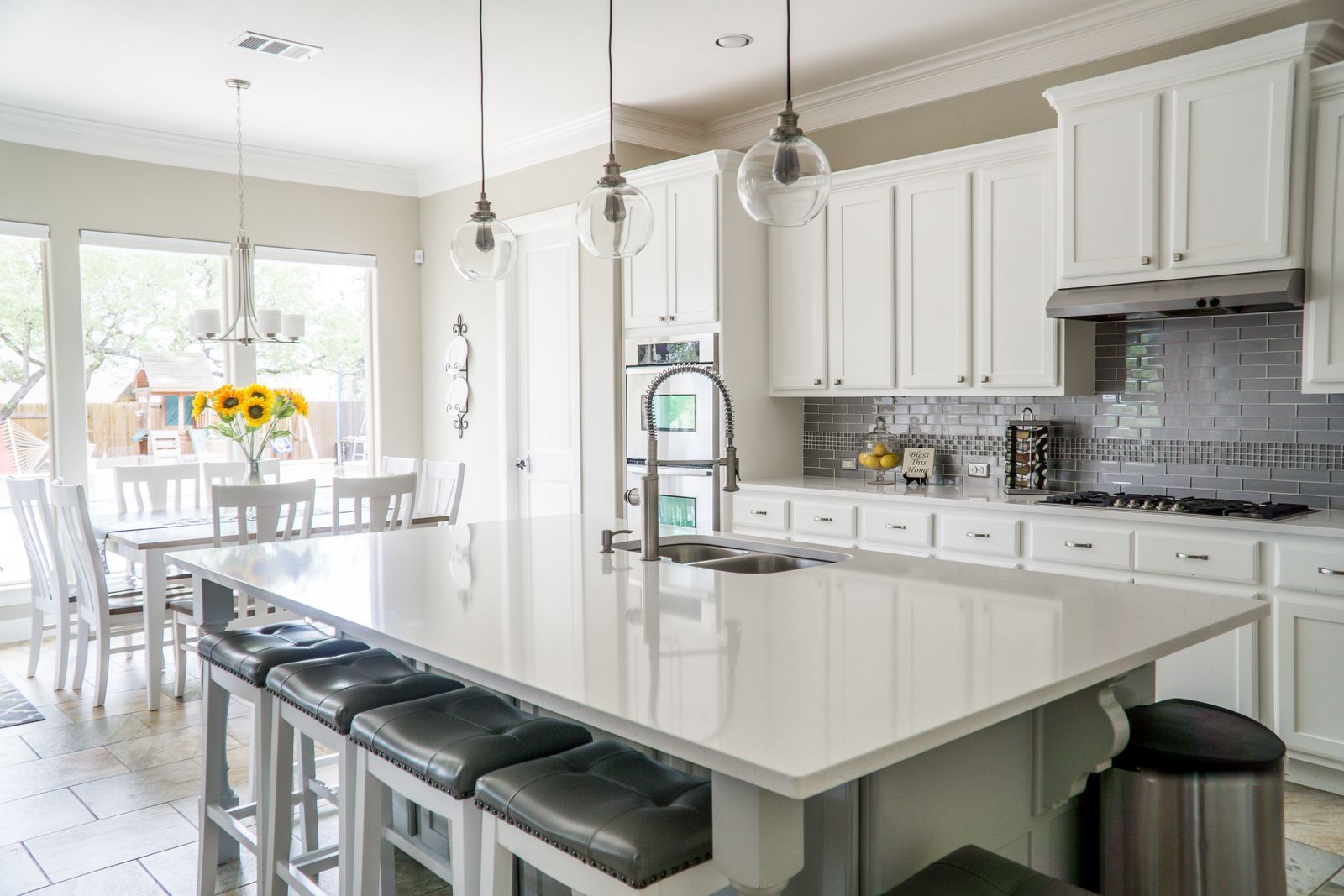 White kitchen with a large island and pendant lights
